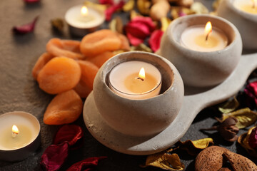 Burning candles with treats for celebration of Divaly on dark background