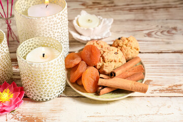 Burning candles with treats for celebration of Divaly on table