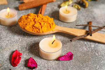 Festive composition with burning candles and spices for celebration of Divaly on grey background