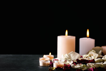 Burning candles and flower petals for celebration of Divaly on dark background