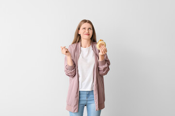 Woman with problem of strong hunger on light background. Diabetes symptoms