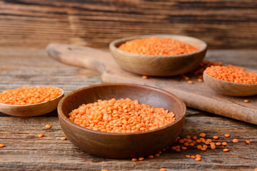 Bowl with raw lentils on wooden table