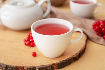 Cup of healthy viburnum tea on table