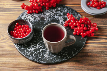 Cup of healthy viburnum tea on table