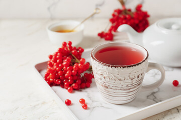 Cup of healthy viburnum tea on table