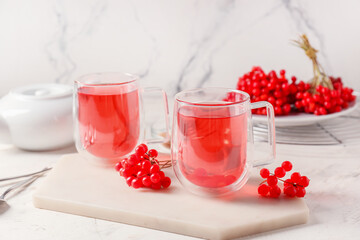 Cups of healthy viburnum tea on table