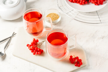 Cups of healthy viburnum tea on table