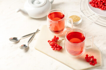 Cups of healthy viburnum tea on table