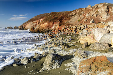 Fototapeta na wymiar Rugged Coastline and Sea Foam at Rockaway Beach. Pacifica, San Mateo County, California, USA.