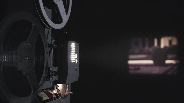 Old 8 mm projector showing film on screen, 4k