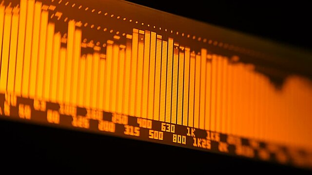 The professional concert equalizer has a yellow spectrum analyzer on the display that analyzes the frequency range of music or any sound and can change it. Closeup