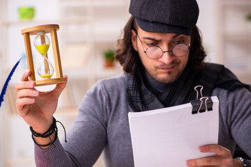 Young male writer in time management concept