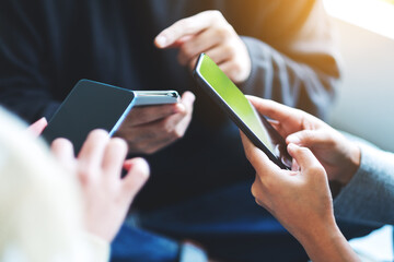 Group of young people using and looking at mobile phone together