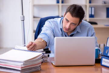 Young male employee suffering at workplace