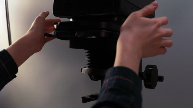 Young photographer &nbsp;placing the negative in the enlarger carrier.