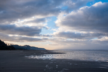 A cloudy morning over a reflective beach on the Pacific Ocean