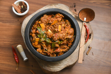 Kerala food nadan spicy chicken curry also a popular Sri Lankan food kalupol chicken curry Devilled Chicken side dish or Chettinad chicken curry with coconut pieces , Tamil Nadu India in clay pot.