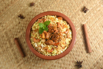 Mutton biryani , Gosht or lamb biryani or Hyderabadi Dum biriyani with raita yoghurt dip special occasion festival food  for Ramadan , Eid Hyderabad India in clay or earthen pot 