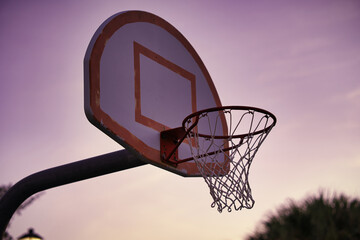 basketball hoop against sunrise sky © John