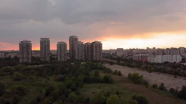 City panorama panning left-right drone movement at sunset. The shot was taken at Vacaresti Urban Delta looking over the central area of Bucharest, the capital city of Romania.