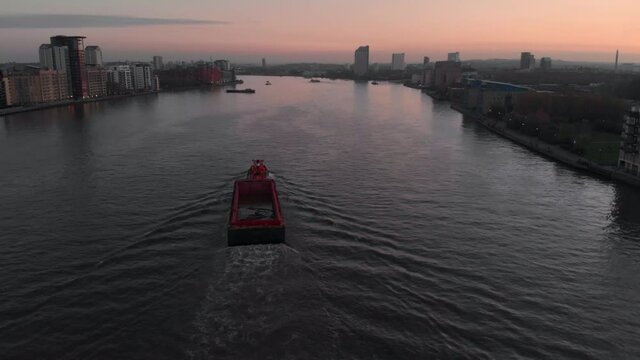 drone follow shot of Barge boat on the Thames river sunset