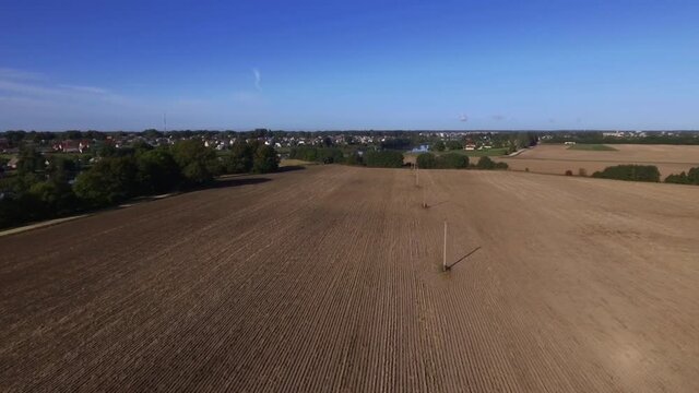 Power Supply Pole Lines In Harvested Agricultural Fields. Aerial Flying Forward Footage.