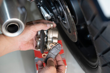 mechanic Replace and adjust motorcycle Rear Brake system,maintenance,repair motorcycle concept in garage .selective focus © kasarp