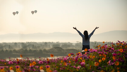 Asian woman relax and freedom in beautiful blooming cosmos flower garden. Travel happy and Lifestyle Concept. © tonjung