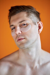 Obraz premium portrait of handsome caucasian guy with transparent patches for dark circles under eyes, enjoy and relax isolated over yellow background