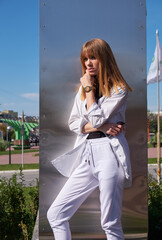 Young blonde woman. Female model posing on metal background