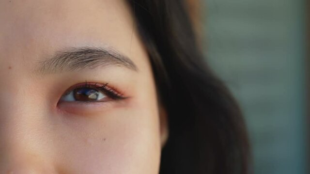 Close up. Happy asian woman opening the eye with make up. Beauty shot. High quality 4k footage