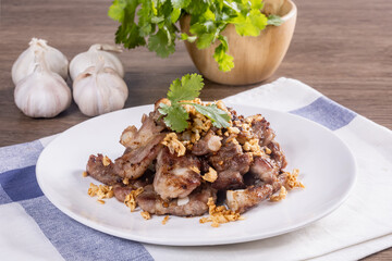Garlic and pepper pork bones fried on a wooden table