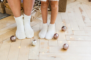 mother and daughter's feet in new year's warm white socks and gifts decor for home decoration