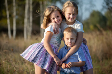 Fototapeta premium Little brother and two sisters are looking at the camera.