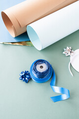 diy Christmas gifts packaging , bundle of white and blue satin ribbon and minimalistic rolls of paper for self-wrapping gifts. blue monochrome, selective focus