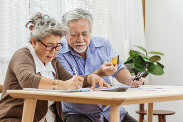 Stressed senior elderly couple conclict of credit card bills or bebt of expense in shopping. Lover...