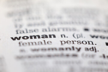 Macro close up of old English dictionary page with word woman