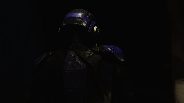 Cyberpunk concept, future world. Police officer halfman bionic cyborg or android is walking through the night area of the city. Science fiction scene, fantasy, sci. World of tomorrow. Neon lighting