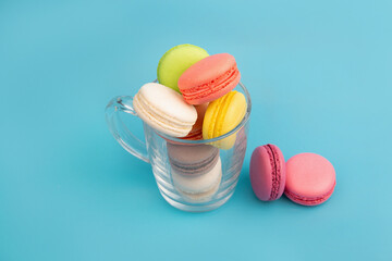 French multicolored macaroons in a transparent cup. Dessert.