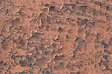 Old paint on the surface for the backdrop. Close-up. Peeling and flaking of paint. Light brown color. Black spots.