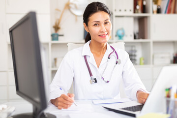 Portrait of positive female doctor in hospital interior