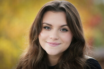 Naklejka premium Close up Portrait of 18 Years Old Beautiful, Gorgeous Girl with Long Brown hair and Big eyes, Blurry Fall Background, Happy Teenager 