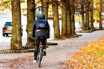 Rider cycling on the road bike in the city in autumn, sustainable transport concept