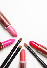 lipsticks and make-up brushes isolated on white