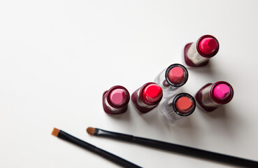 lipsticks and make-up brushes on white