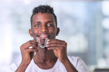 Handsome African Young Man Is Holding An Invisaligner, image with copyspace