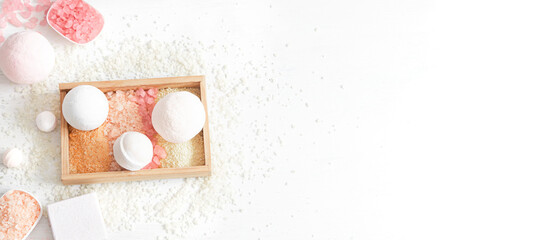 Composition with multi-colored sea salt and bath bombs on a white background.