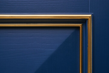 Classic wood entrance door in dark blue with carved panels and gold patina