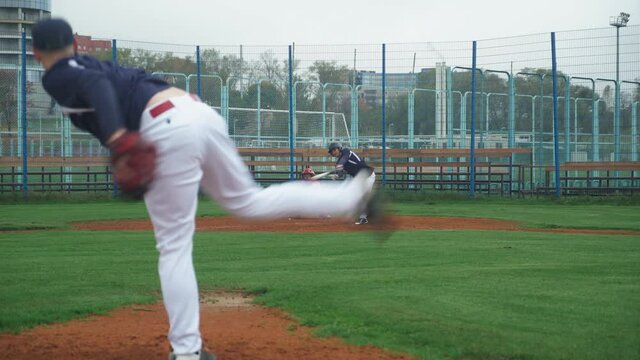 College sports, guys play baseball, the pitcher throws ball towards the batter, batter successfully hits the fastball and run to base.