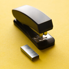 A set of office supplies. Stapler and staples on yellow background.